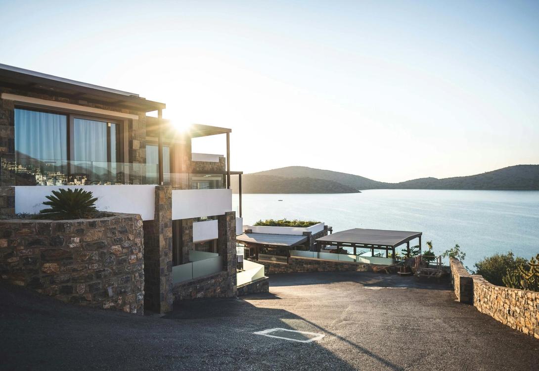 A photo of a modern house with a picturesque landscape of the sea and some islands in the background