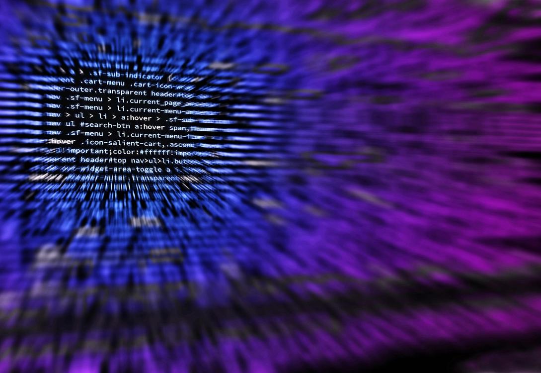 A computer screen displaying lines of code, overlaid with a smooth purple-to-blue gradient.