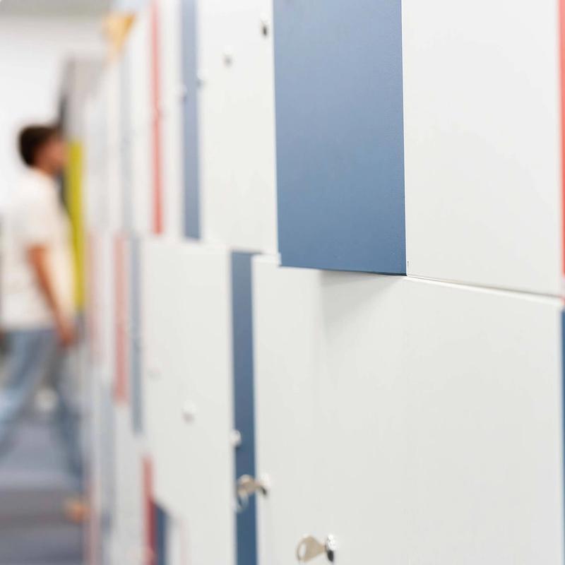 A depth-of-field shot of a row of lockers with people walking past them in the background and out of focus
