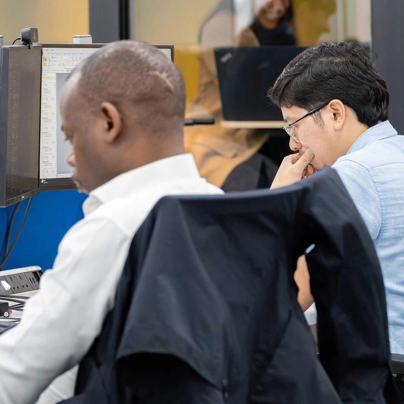 A pair of C5 Team Members working at their desks in the C5 office