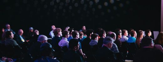 Agroup of delegates at a conference event all looking towards the presenter who is out of shot