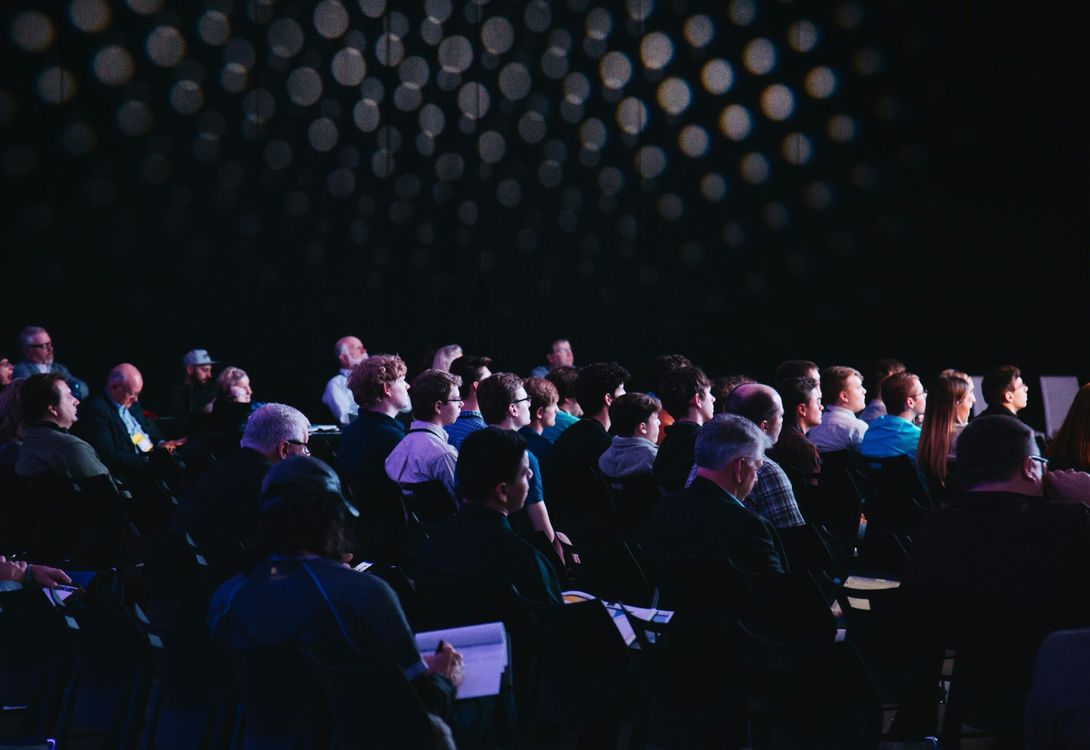 Agroup of delegates at a conference event all looking towards the presenter who is out of shot