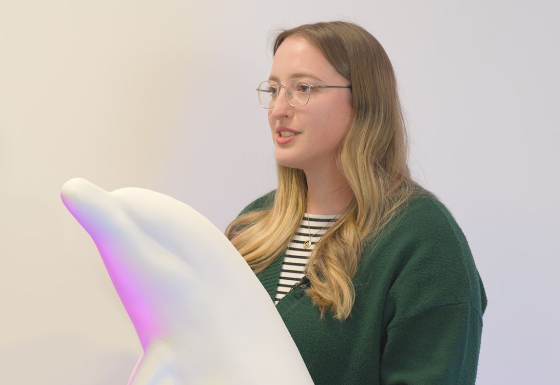 An artist next to the sculpture of a dolphin that they will be decorating for the Guernsey Dolphin Trail 2025