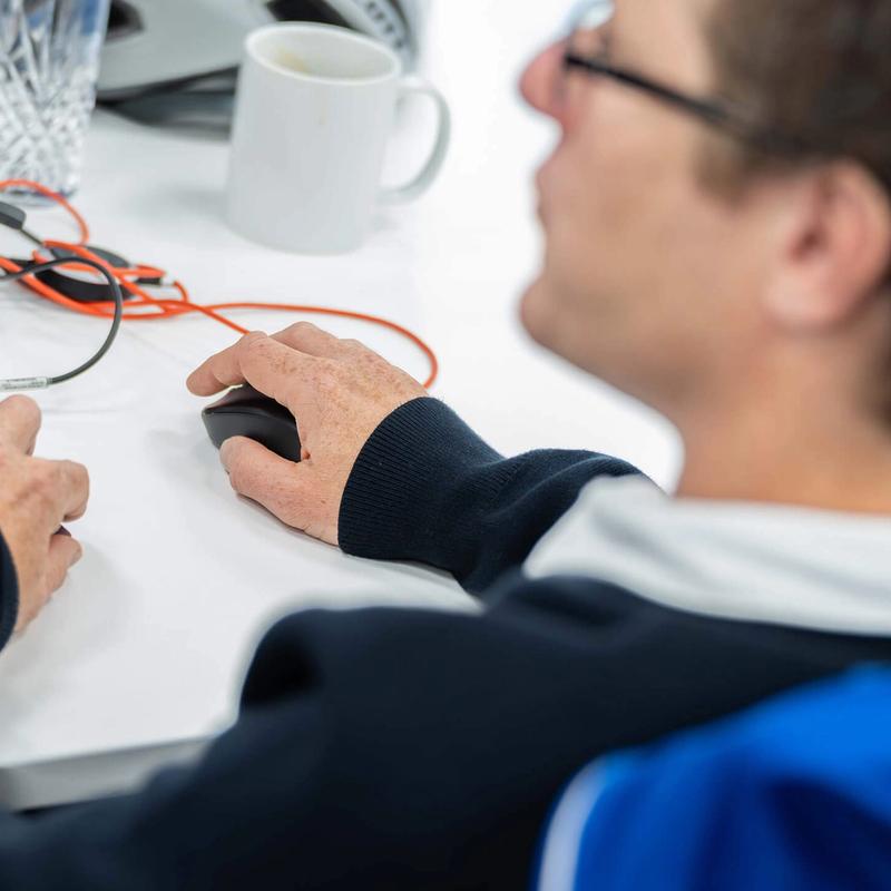 A male C5 Team member works on his laptop at his desk