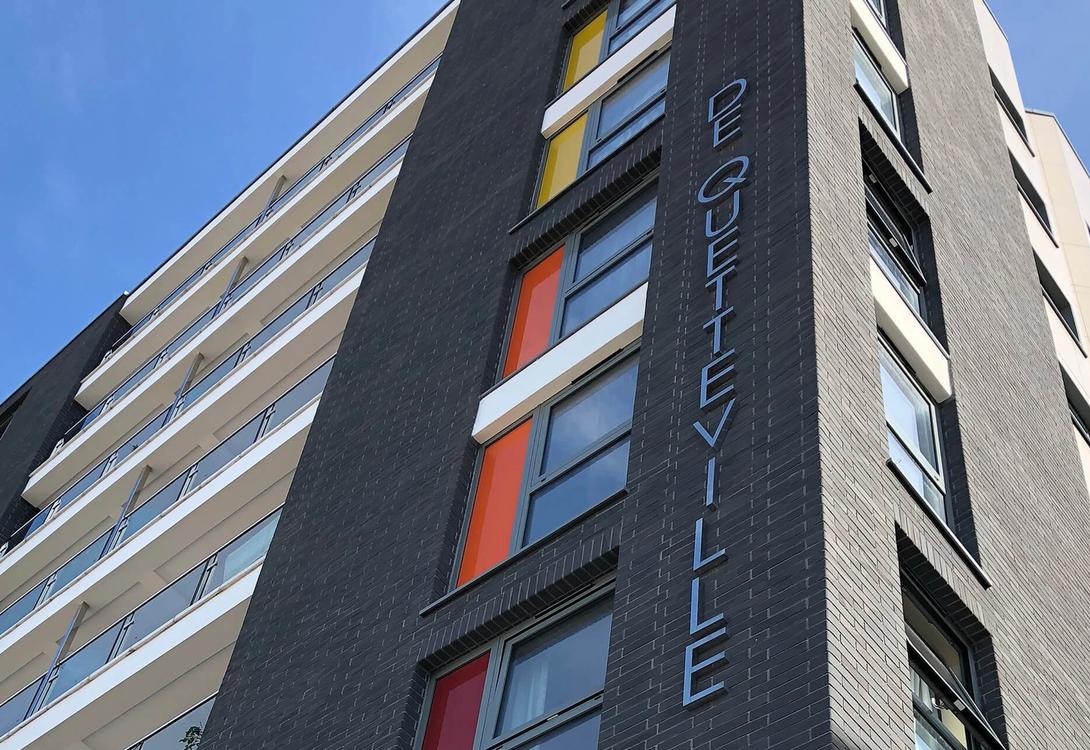 A photo of a block of flats in St Helier jersey looking upwards and the newly restored building from a low angle